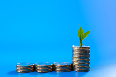Business Money and Saving Concept. Closeup of stack of silver coins with green leaf young shoot on...