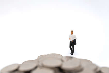 Business, Money Investment and Planning Concept. Businessman miniature figure people figure walking to pile of silver coins on white background.の写真素材