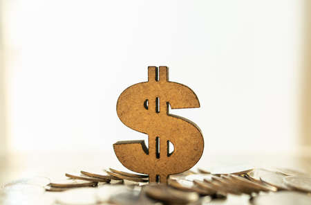 Global Business and Money Concept. Closeup of wooden US Dollar sign on pile of silver coins.の写真素材