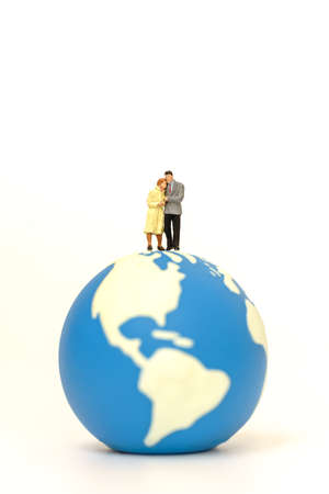 Couple and Global concept. Two businessman and businesswoman miniature figure people walking and standing on mini world ball on white background.の写真素材