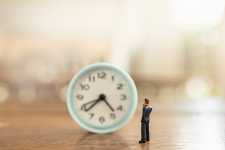 Business and Time Management Concept. Businessman miniature figure people standing and looking to...