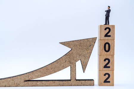 2022 New Year and Business Planning Concept. Closeup of businessman miniature figures standing on...