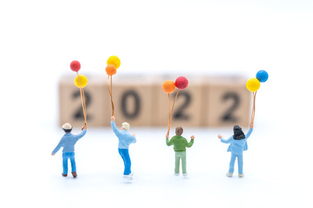 2022 New Year and Family Concept. Group of children kid miniature figures with balloon plaing ...