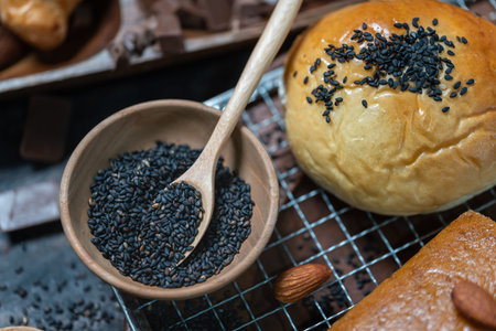 Closeup of wooden bowl of black sesame with bread