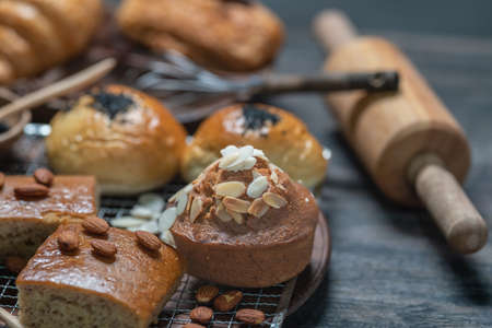 Closeup of almond muffin and assort bakery with cooking assessories on wooden table.の写真素材