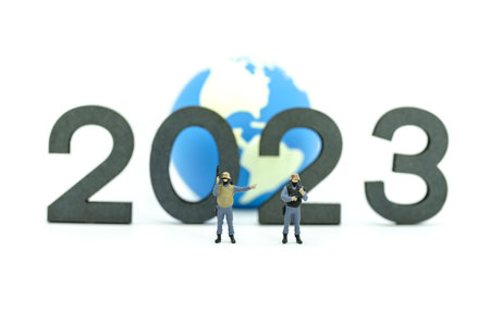 2023 Global Business and security New Year Concept. Closeup of group of soldier  miniature figures with machine gun standing with wooden number and mini world ball on white background.の写真素材