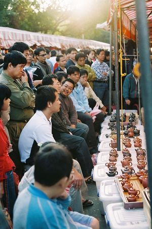 Crowd is attracted by a stall that sold chinese style tea pot, in a late afternoon local market of Hsinchu city, Taiwan. A glance of daily life of people in Taiwan.のeditorial素材