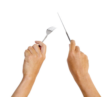 hands holding knife and fork, with movement like cutting a steakの写真素材