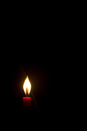 a burning candle in darkness, with copy space.の写真素材