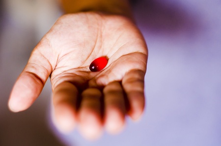a red tablet is handed out by a woman.の写真素材