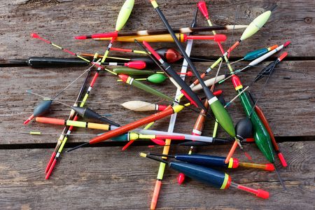 Scattered fishing floats in different shapes on wooden backgroundの写真素材