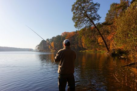 fisherman catching the fish at sunny autumnal dayの写真素材