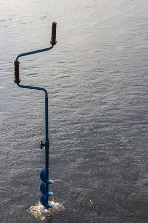 hand ice auger on the ice