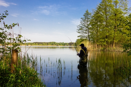 Angler catching the fish during sunny dayの写真素材
