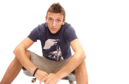 portrait of a skater sitting on his skateboardの写真素材