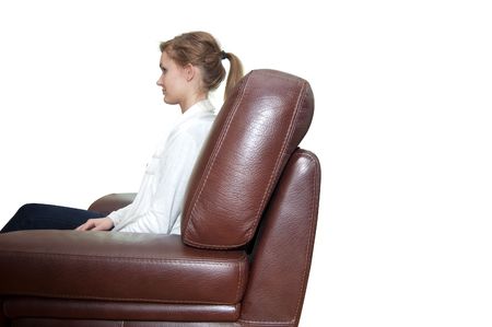 young girl sitting in a leather armchairの写真素材