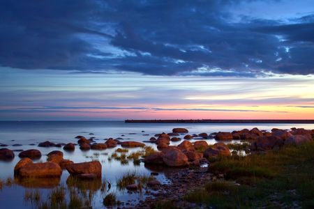 Sunset in a calm bay full of stonesの写真素材
