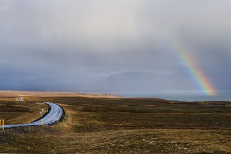 Landscape with rainbow and road in Icelandの写真素材