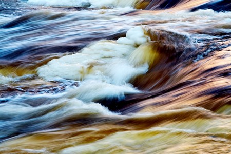 Fast icy river with blurred water in motionの写真素材