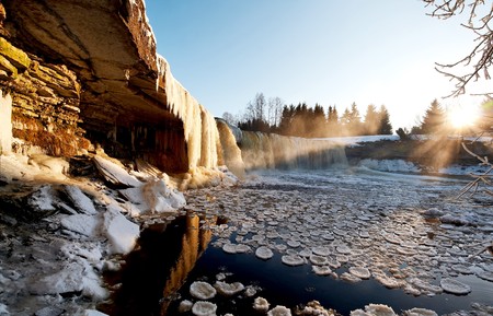 Icy winter waterfall in light of evening sunの写真素材