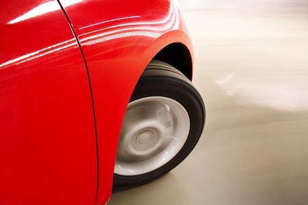 Front wheel of red car in motionの写真素材