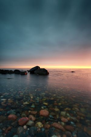 Pebbles under water on sunsetの写真素材