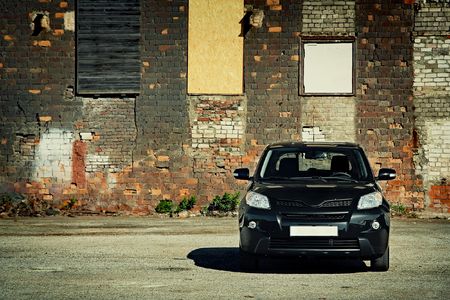 Front view of modern crossover vehicle near old brick wallのeditorial素材