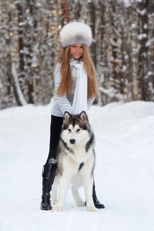 Young woman in winter park with dogの写真素材