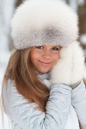 Young woman in a fur-cap in a winter forestの写真素材
