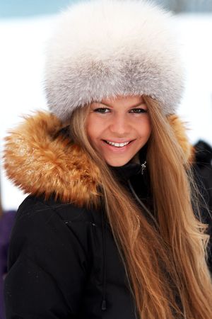 Young woman in fur-cap on a winter sea coastの写真素材