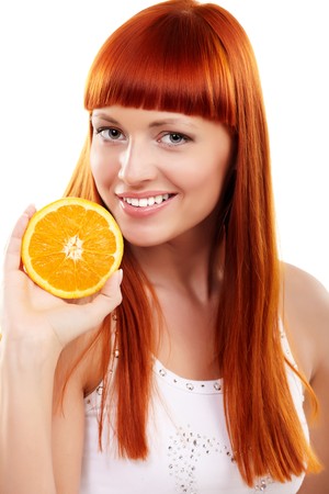 Young redhead woman with orange isolated on whiteの写真素材