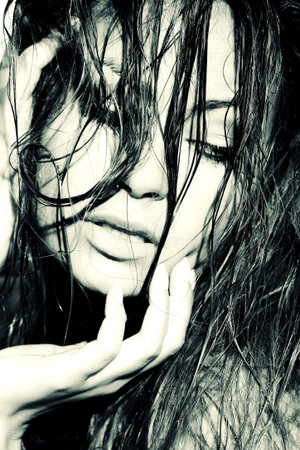 Closeup portrait of young glamorous woman with wet hair touching her hair 