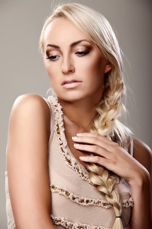 Portrait of a young lady with a braid on grey backgroundの写真素材
