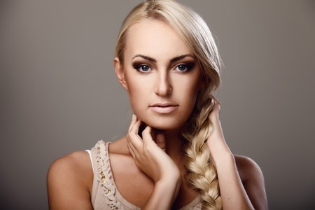 Portrait of a young lady with a braid on grey backgroundの写真素材