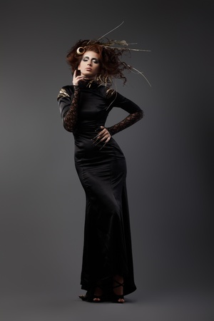 High fashion model in black dress, with long nails and creative hairstyling on grey backgroundの写真素材