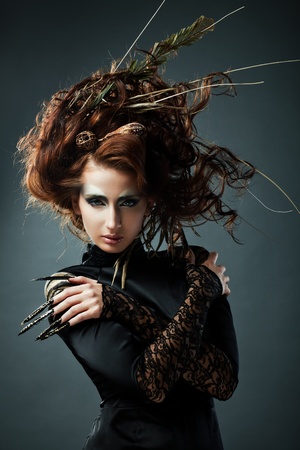 High fashion model in black dress, with long nails and creative hairstyling on grey backgroundの写真素材