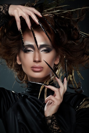 High fashion model in black dress, with long nails, creative hairstyling and makeupの写真素材