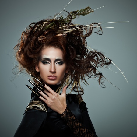 High fashion model in black dress, with long nails and creative hairstyling on grey backgroundの写真素材