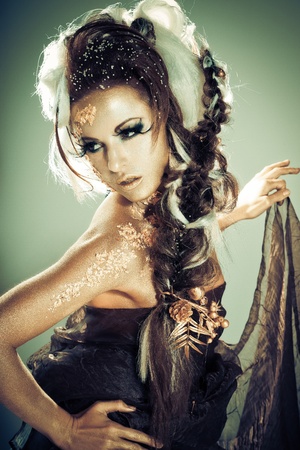 Vogue style portrait of a woman with gold-silver bodyart and makeupの写真素材