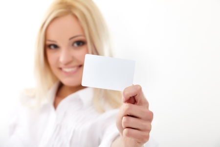 Happy blond woman showing blank credit card. Focus on card.の写真素材