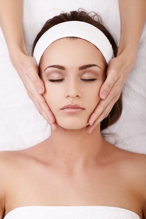Beautiful young woman enjoying a facial massageの写真素材