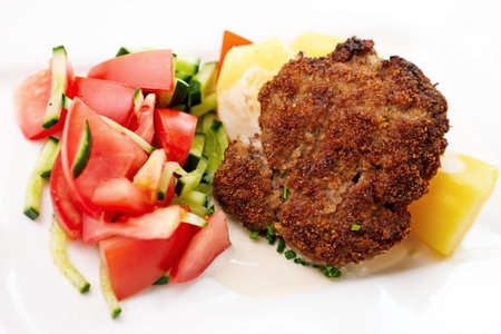 Minced meat cutlet with boiled potatoes and tomato-cucumber salad