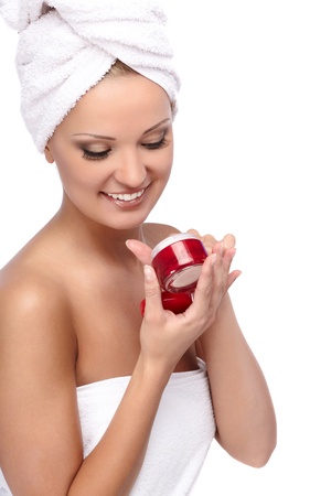 Young beautiful lady with a towel on her head applying cremeの写真素材