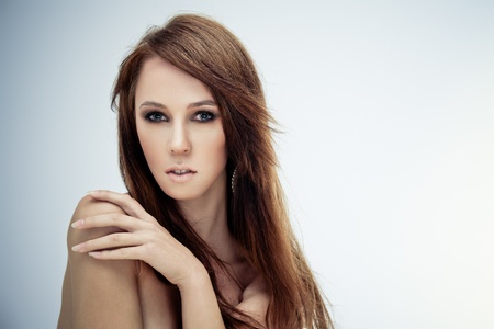Young brunette lady posing on grey backgroundの写真素材