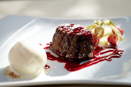 Chocolate fondant with vanilla ice cream and raspberry sauceの写真素材