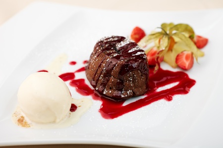 Chocolate fondant with vanilla ice cream and raspberry sauceの写真素材
