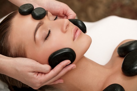 Woman lies on a table in a beauty spa getting a treatmentの写真素材