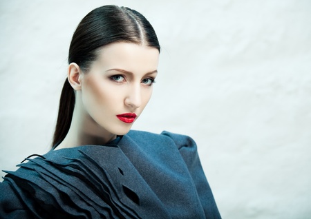 Fashion portrait of beautiful female model covered with blue lightの写真素材