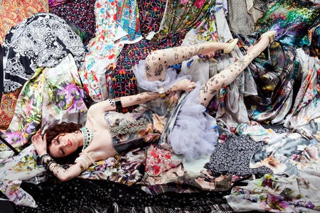 Woman lying on a pieces of colorful fabricsの写真素材