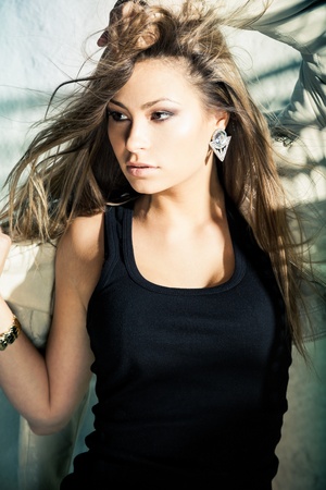 Glamorous young woman in near a wallの写真素材
